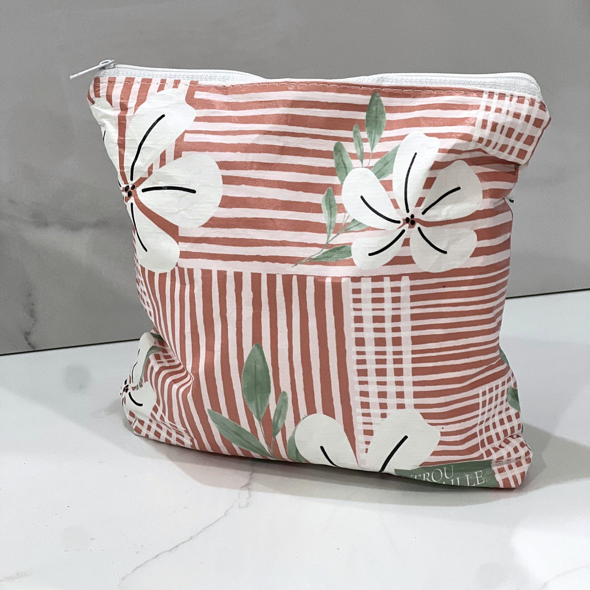 Coral Flowers Small zip pouch on a white marble counter