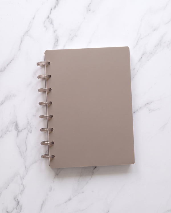 Discbound Starter Kit: a half letter discbound notebook with a taupe cover and 8 translucent taupe discs on white marble