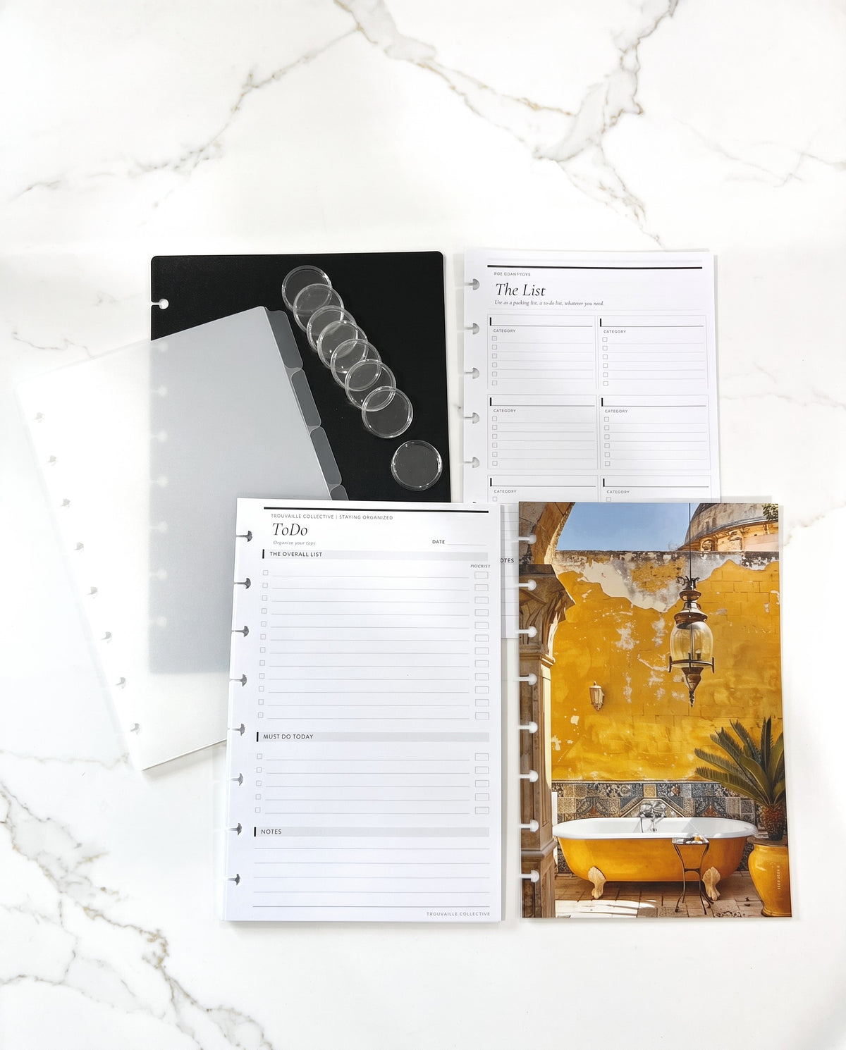 Discbound Starter Kit laid out: black cover, frosted tabbed dividers, 8 clear discs, To Do and The List inserts, and the Yellow Tub dashboard