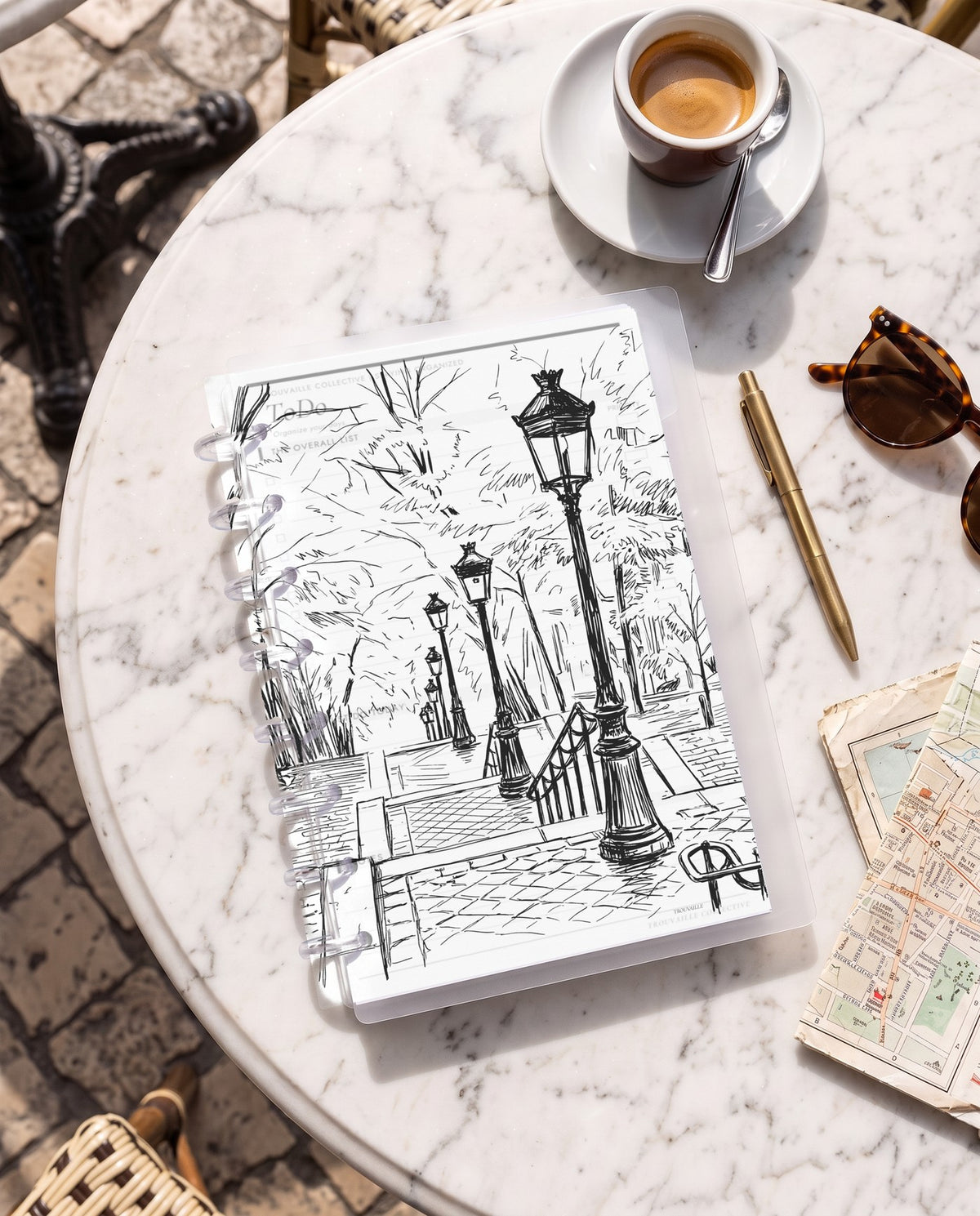 French Steps frosted planner dashboard inside a clear half letter discbound planner with 8 discs on a marble cafe table with espresso