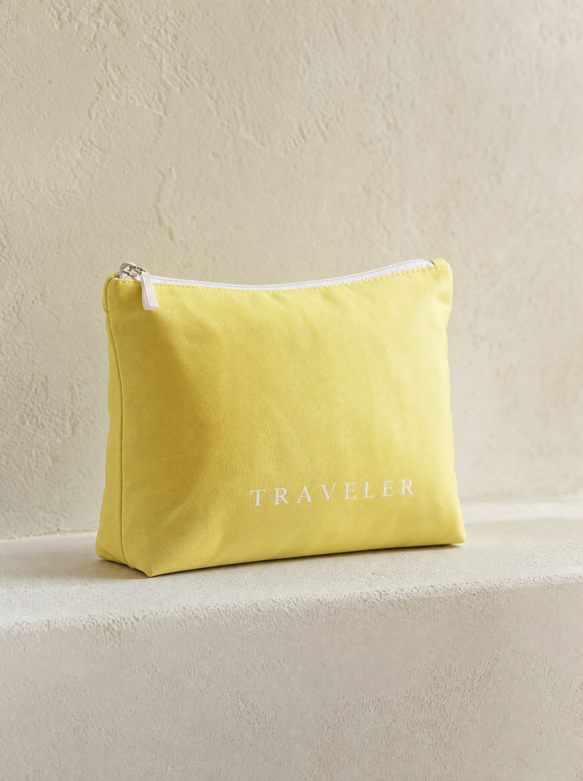 Lemon mini water-resistant accessory bag — a solid yellow 6 x 3.75 inch zip travel pouch with TRAVELER printed in white