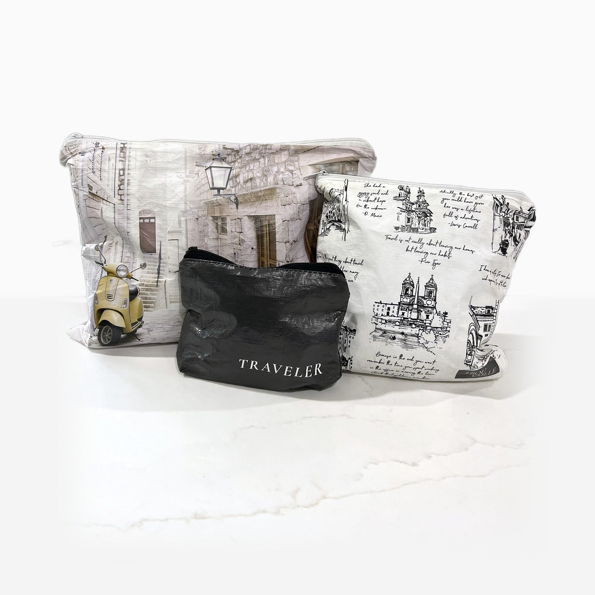 The Neutral Trio water-resistant zip pouches on a marble counter: Italian Alley Medium, Cities Small and Ink Mini