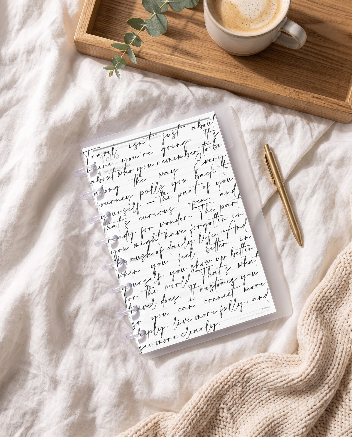 Script frosted planner dashboard inside a clear half letter discbound planner with 8 discs on white linen bedding with a breakfast tray