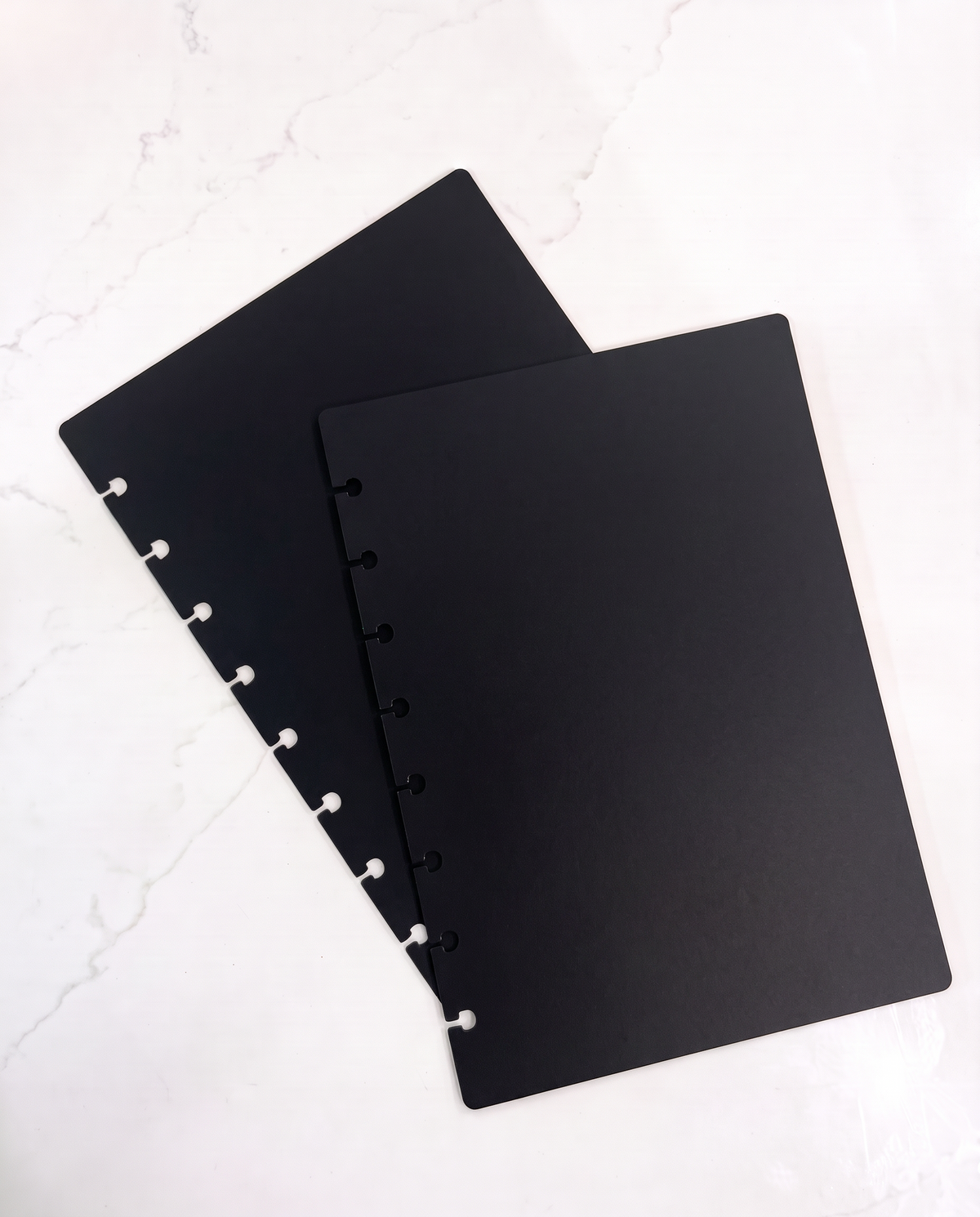 Black matte notebook cover set, front and back, half letter discbound covers on white marble