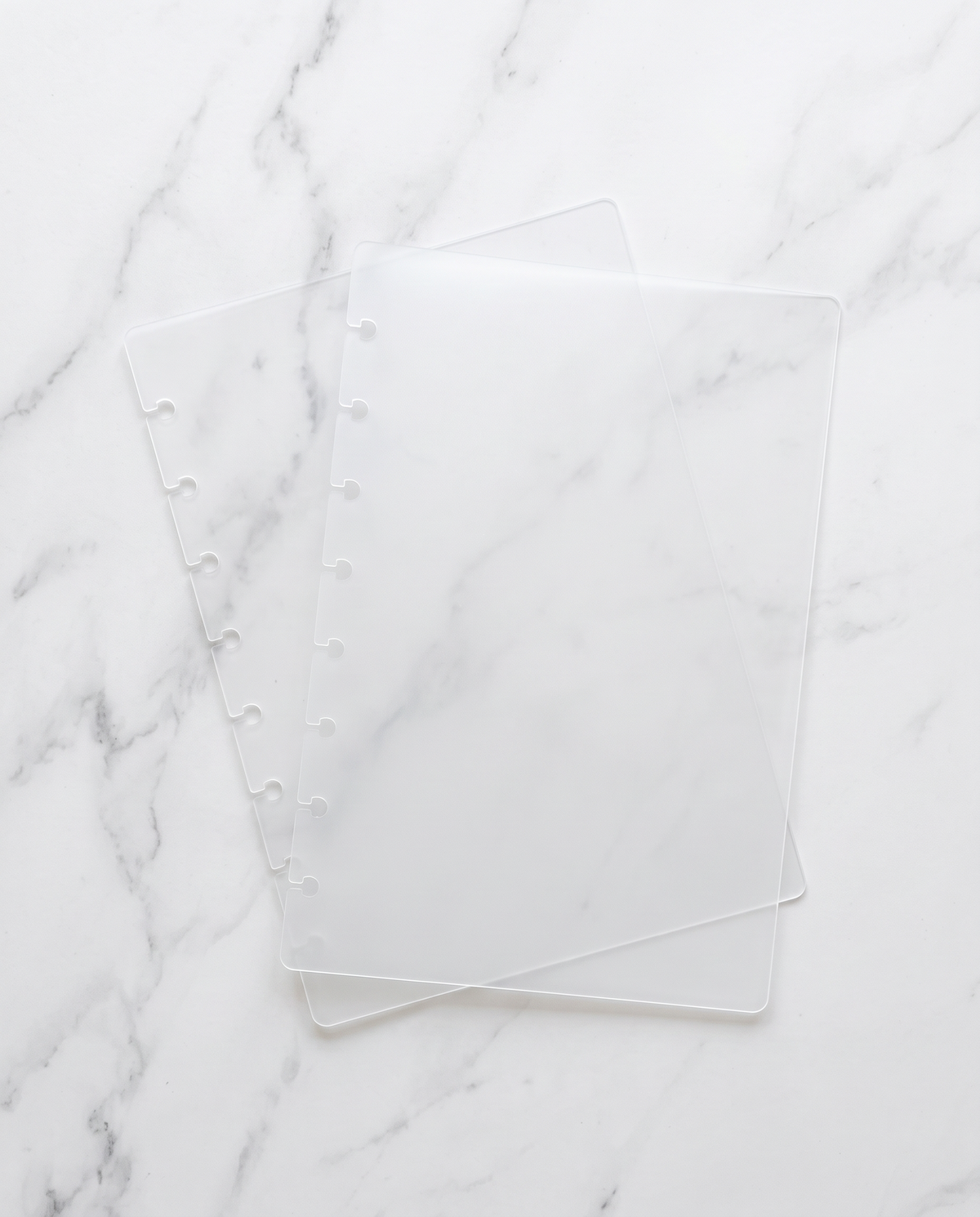 Clear frosted notebook cover set, front and back, half letter discbound covers on white marble