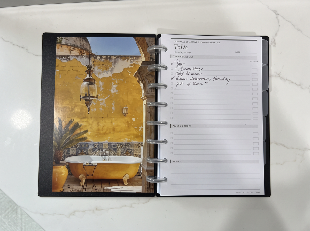Yellow Tub planner dashboard inside an open black discbound planner beside a handwritten To Do page
