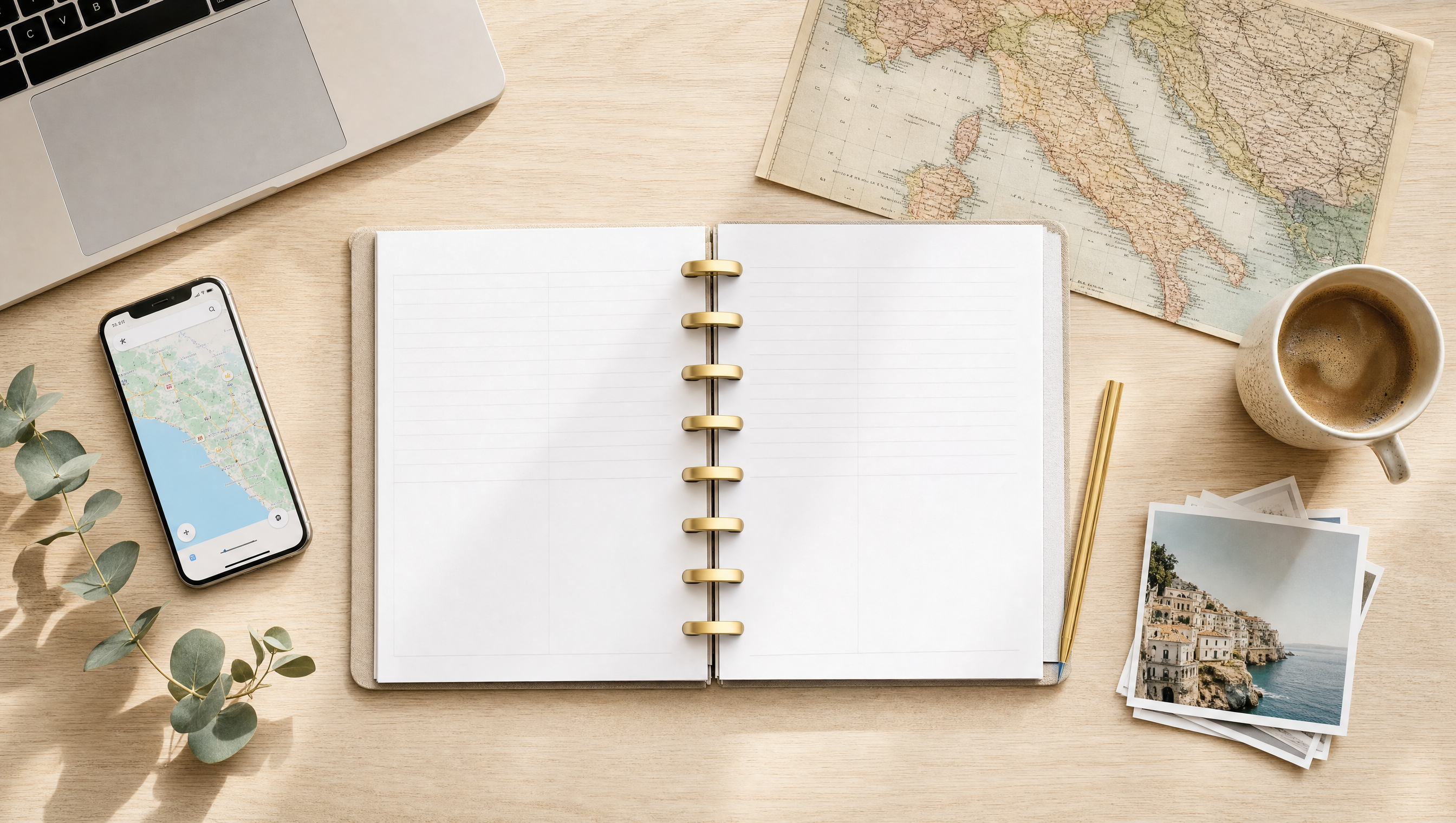 A modern discbound travel planner open on a desk beside a vintage map of Italy, a phone with a map, coffee, and travel photos
