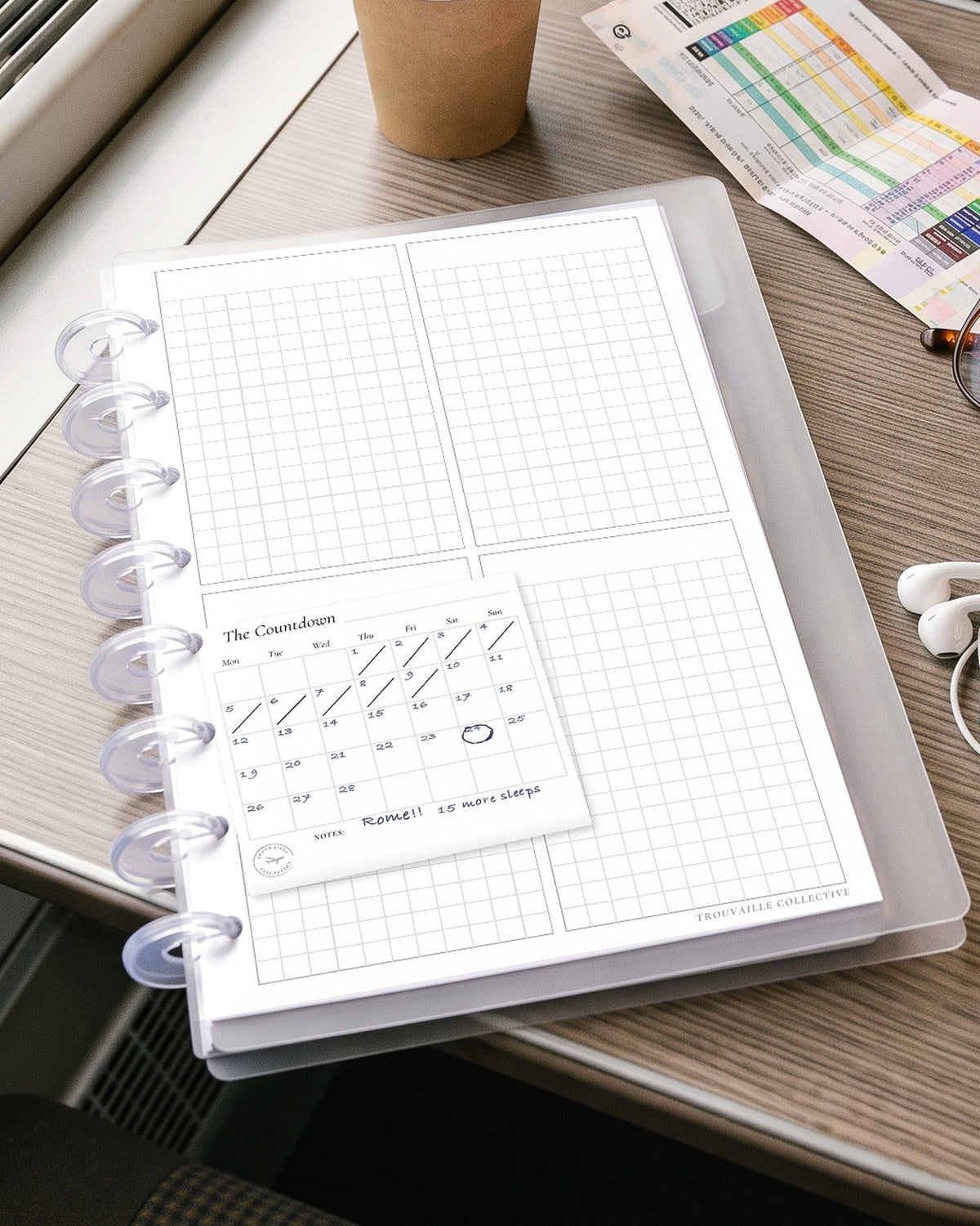 A Calendar sticky note stuck on a planner page in a half letter discbound planner on a train window table, with handwritten notes