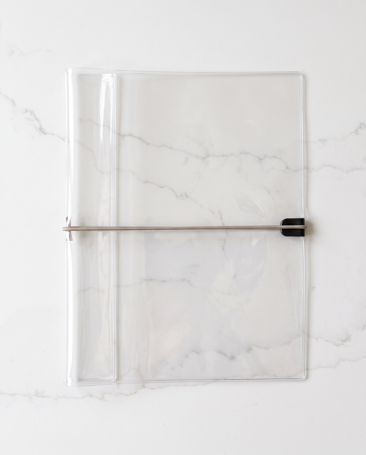 Clear half letter planner binder cover with thin taupe elastic cord