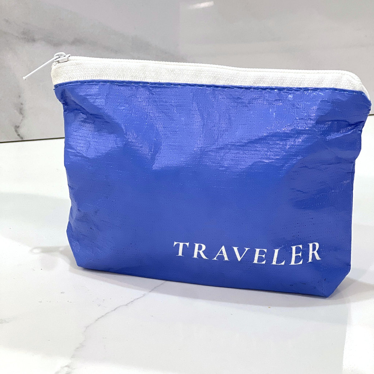 Fresh Water Blue Mini zip pouch sitting on a white marble counter