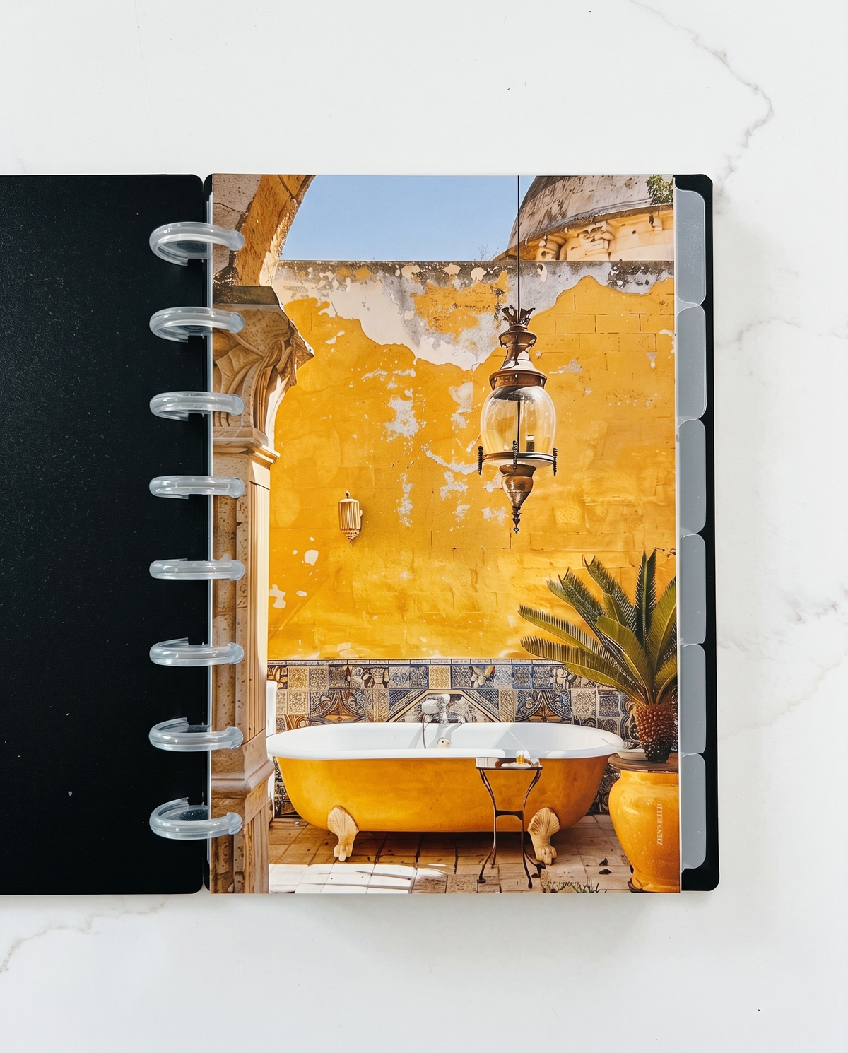 Six frosted divider tabs showing along the edge of a black half letter discbound planner with 8 clear discs and the Yellow Tub dashboard