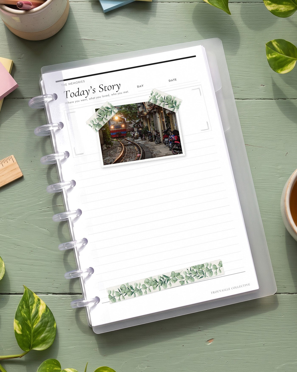 Greenery washi tape on a planner page in a half letter discbound planner on a sage green desk