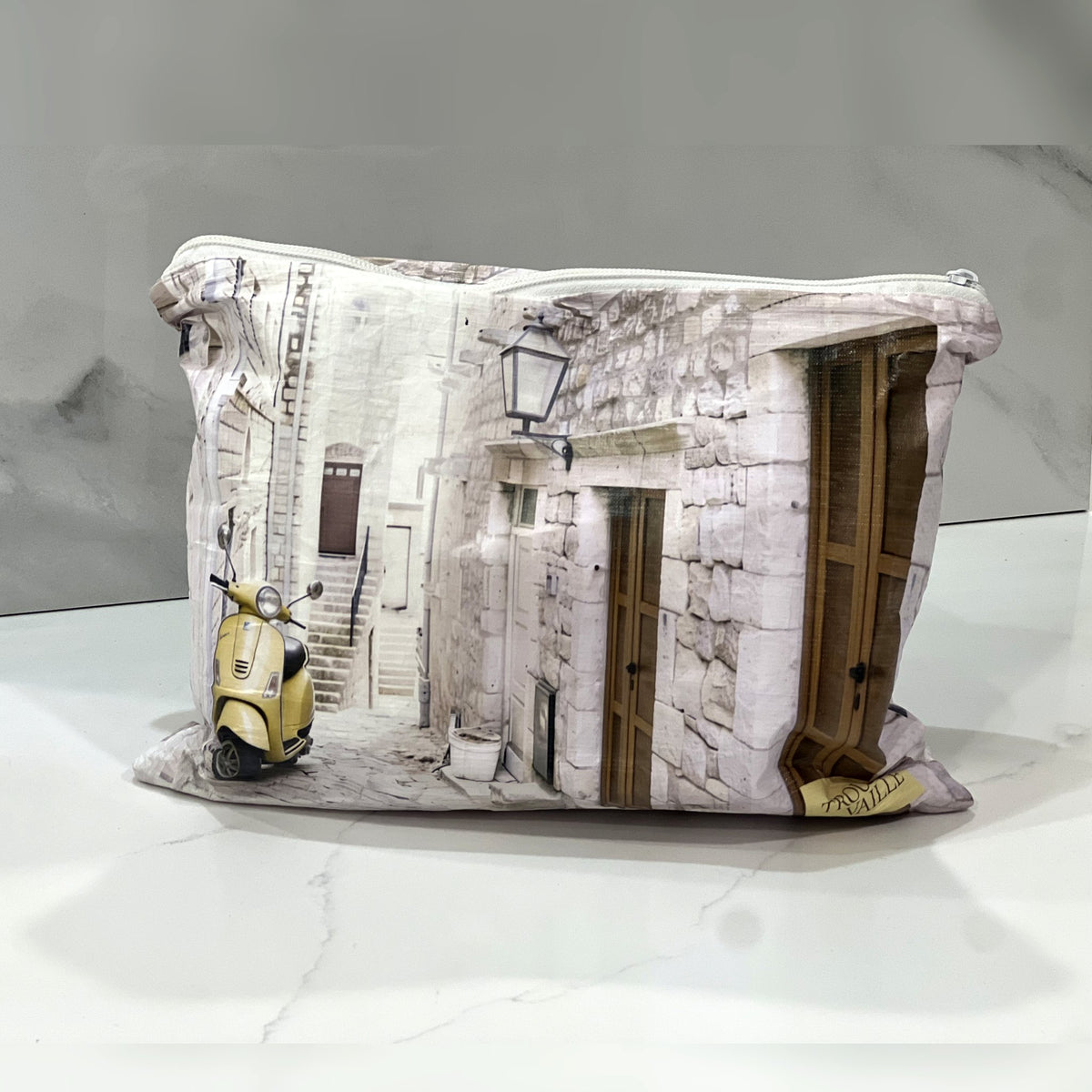 Italian Alley Medium flat accessory bag on a white marble counter