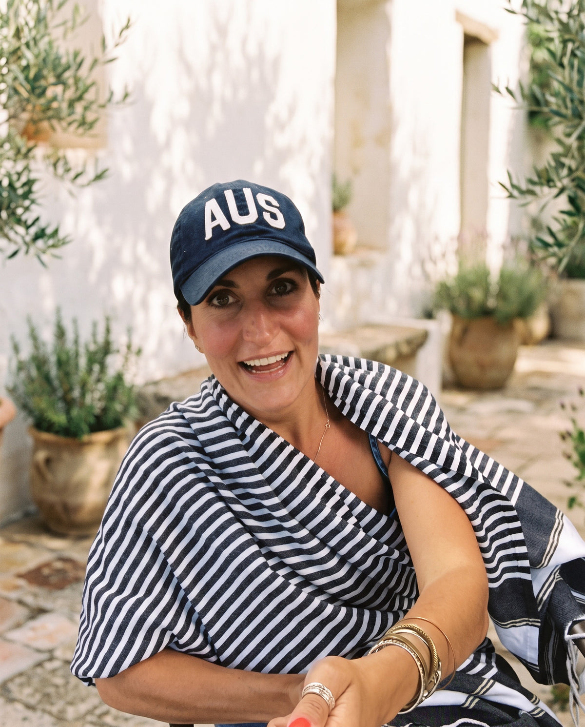 Sairey, founder of Trouvaille Collective, smiling in a sunny white courtyard