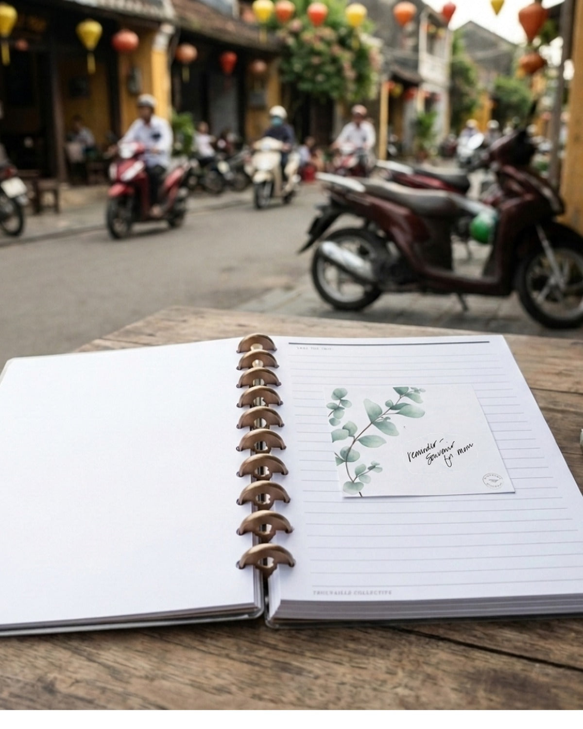 Discbound travel planner pages opening flat on a table in Hoi An, Vietnam